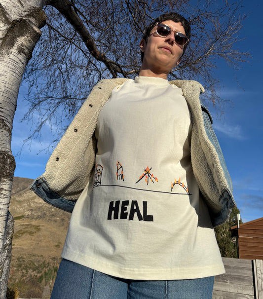 Person wearing a jacket with 'HEAL' text outdoors